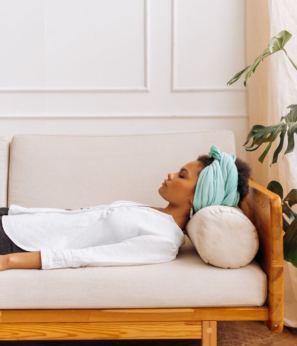 Woman in a calm yoga pose in a softly lit room.